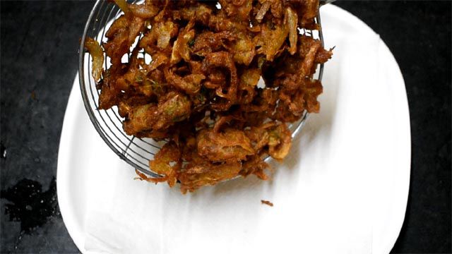 put Crispy Onion Fritters on kitchen towel.