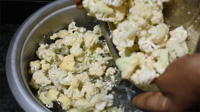 Clean florets to make cauliflower pickle recipe.
